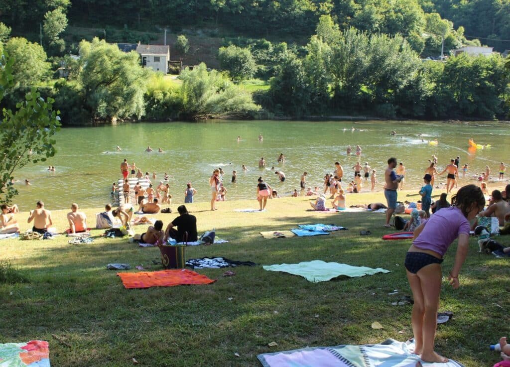 La plage en herbe de la base de loisirs de Trébas-les-bains accueille de nombreux vacanciers sous le soleil d'été au coeur de la Vallée du Tarn et à deux pas de l'Hostellerie des Lauriers